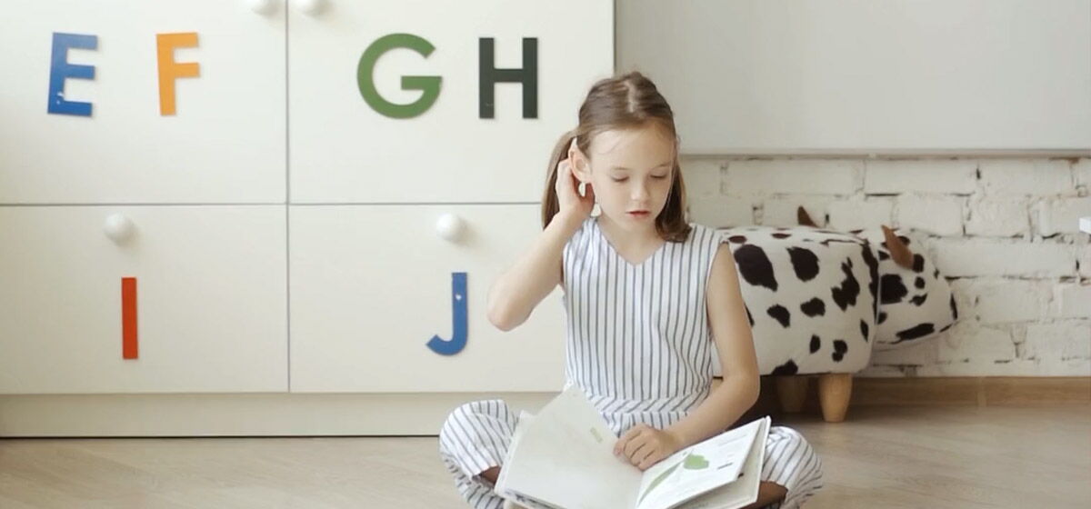 Mädchen beim Englisch Lernen mit einem Buch in der Hand